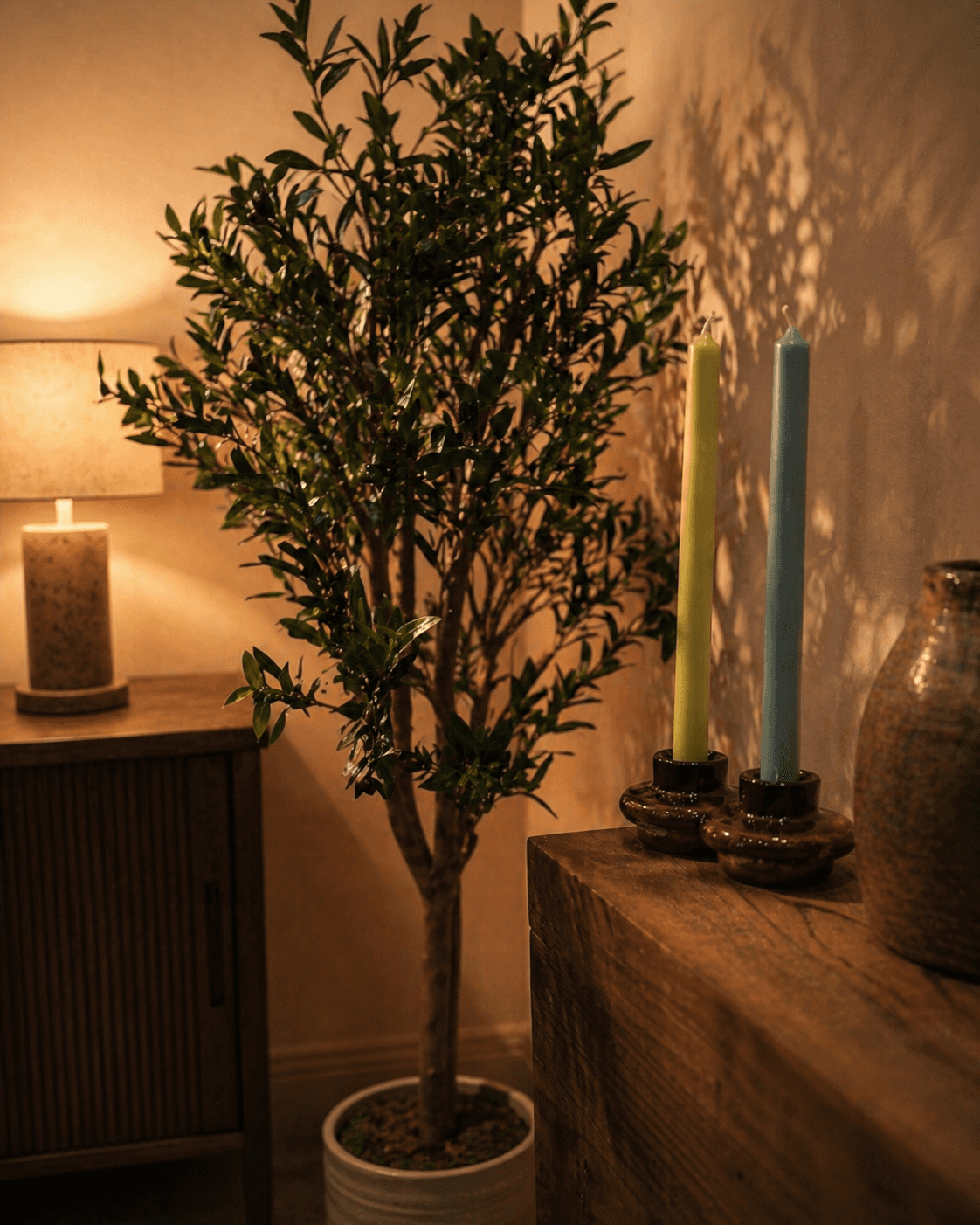 Rammed-earth space with curved walls, wooden seating, and soft daylight from a tall window.
