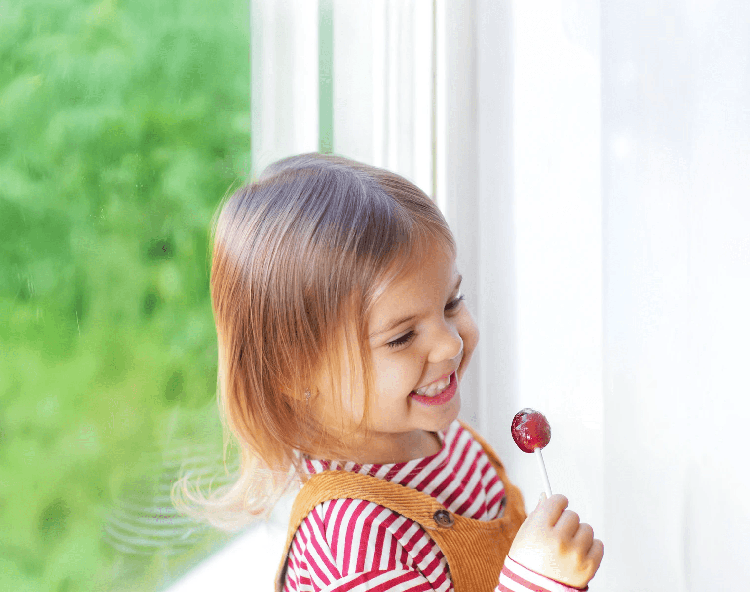 Niña disfrutando de una piruleta OROFAR KIDS como parte del cuidado de la garganta