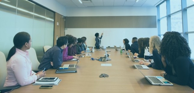 A group of diverse professionals engaged in a discussion, representing teamwork and inclusive strategies in pay equity analysis