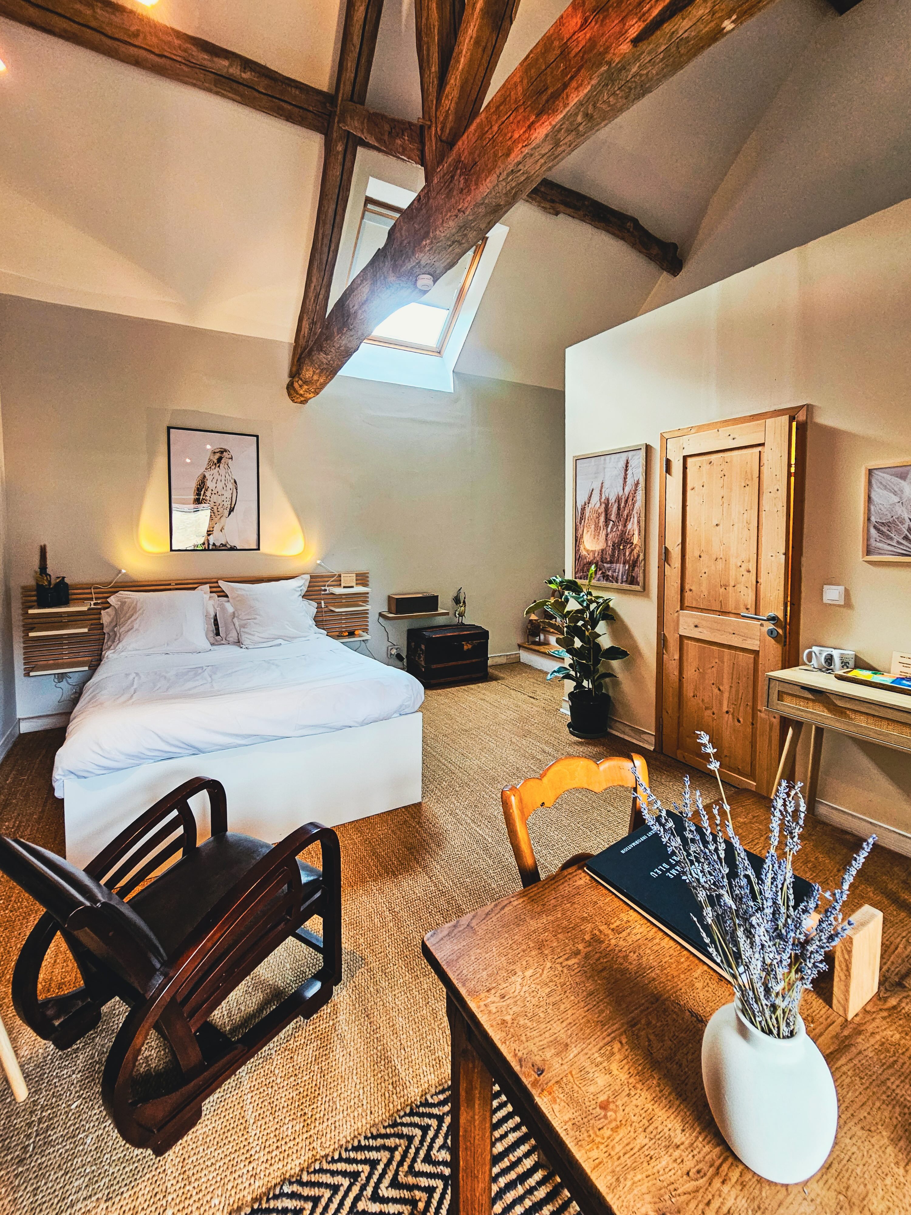 Chambre avec poutres apparentes et lit blanc