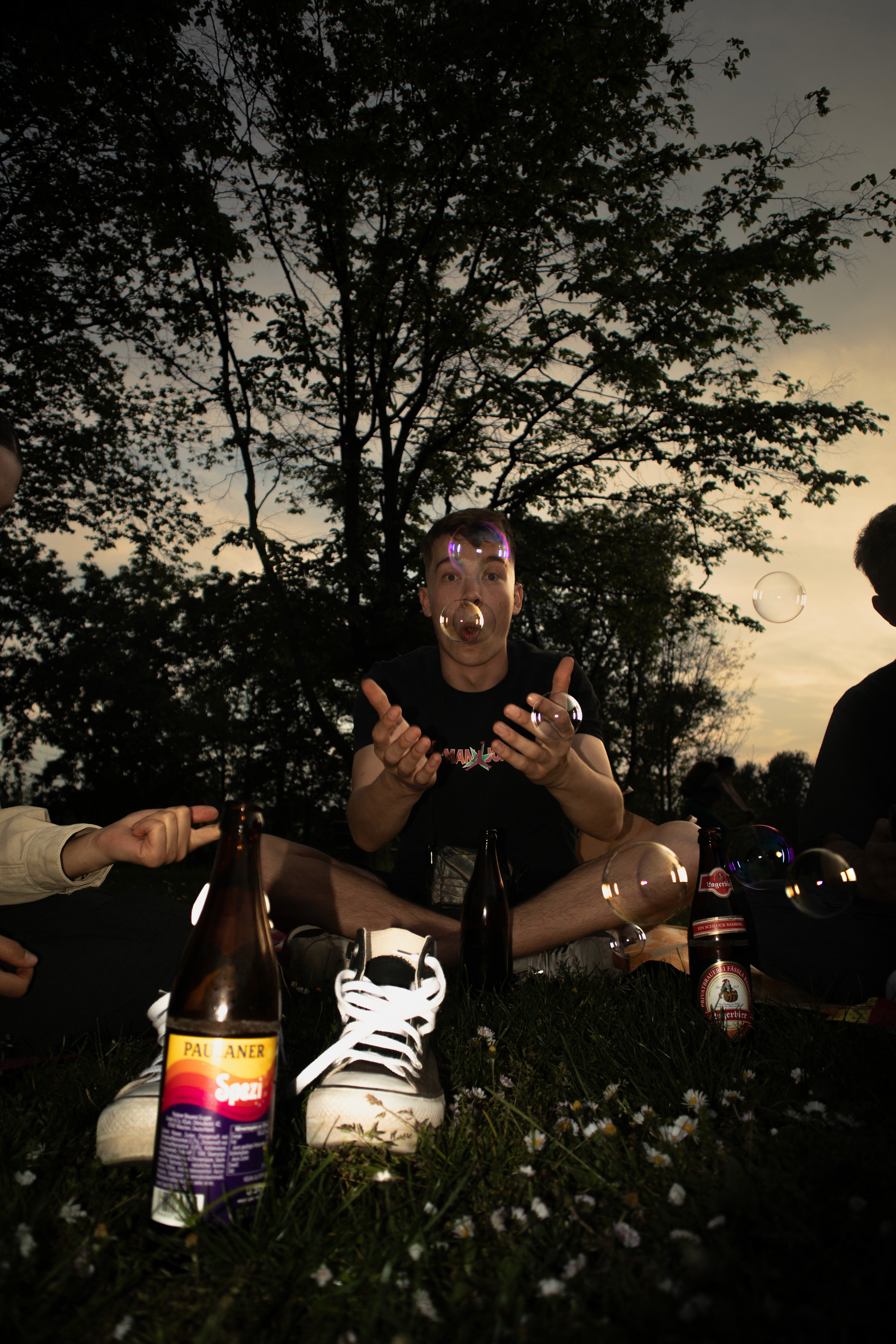 White Guy with a Cola-Mix Softdrink in the foreground being happy with some bubbles blown in the air