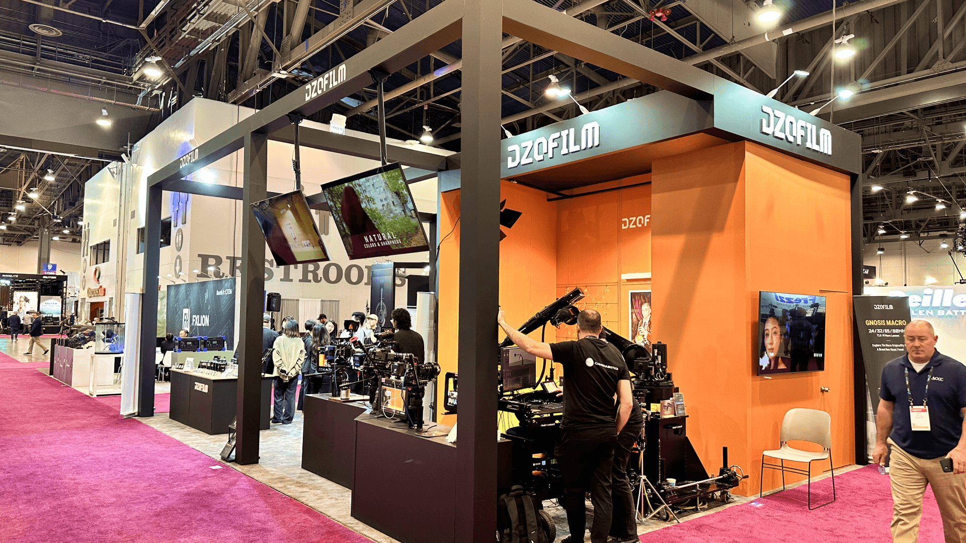 Wide angle view of the matte black open-frame structure supporting overhead monitors and lighting.