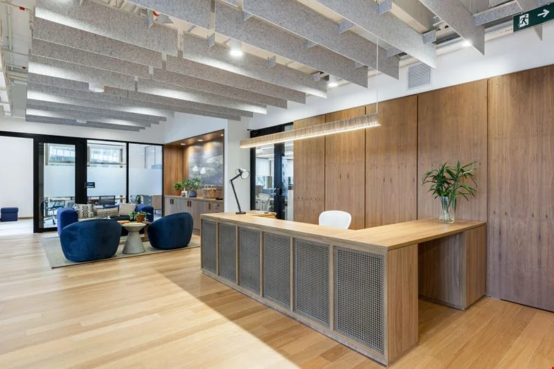 Modern interior space with a blue circular coffee table, flowers in a vase, and books neatly arranged.