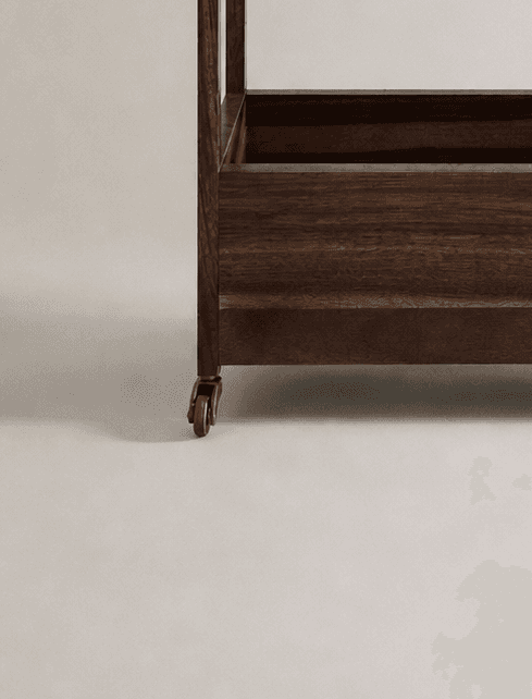 Close up of a Minimalist wooden shelving cart on casters