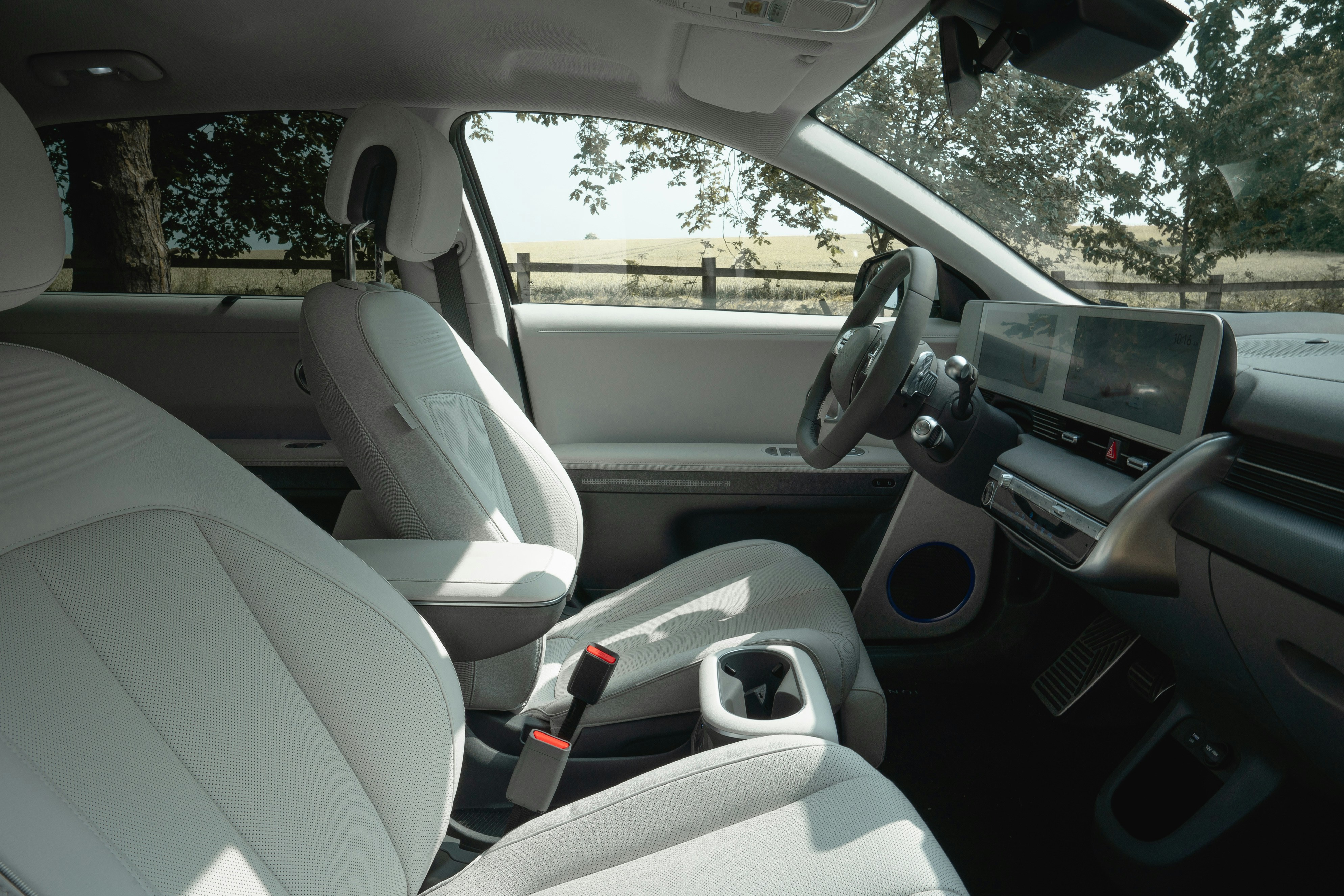 Interior view of a modern car with white seats.