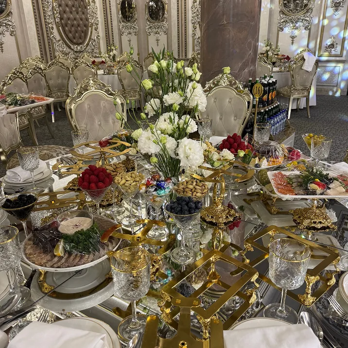 Elegant banquet table with gold accents, crystal glasses, and floral centerpiece