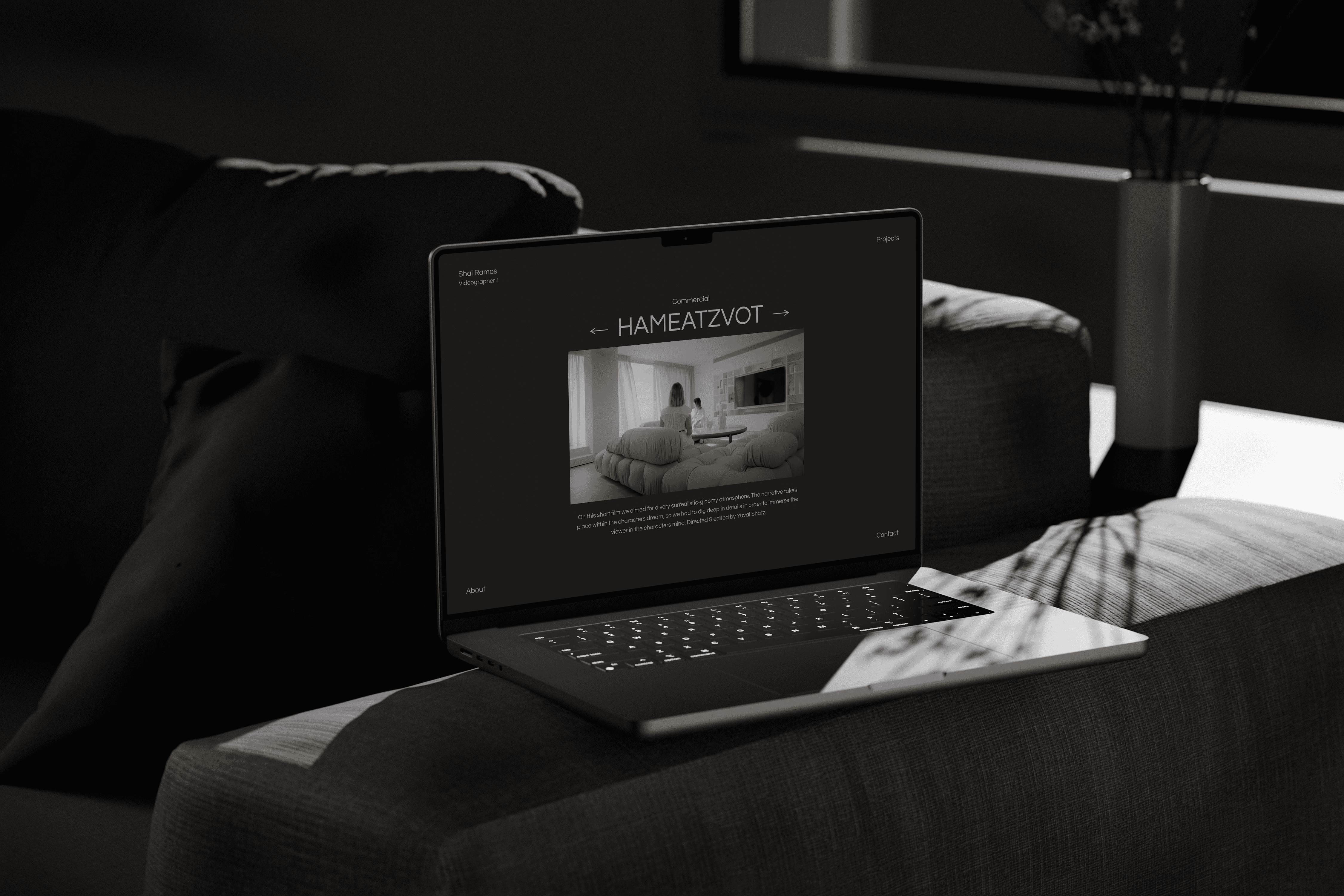 A lap top showing the website on top of a black sofa