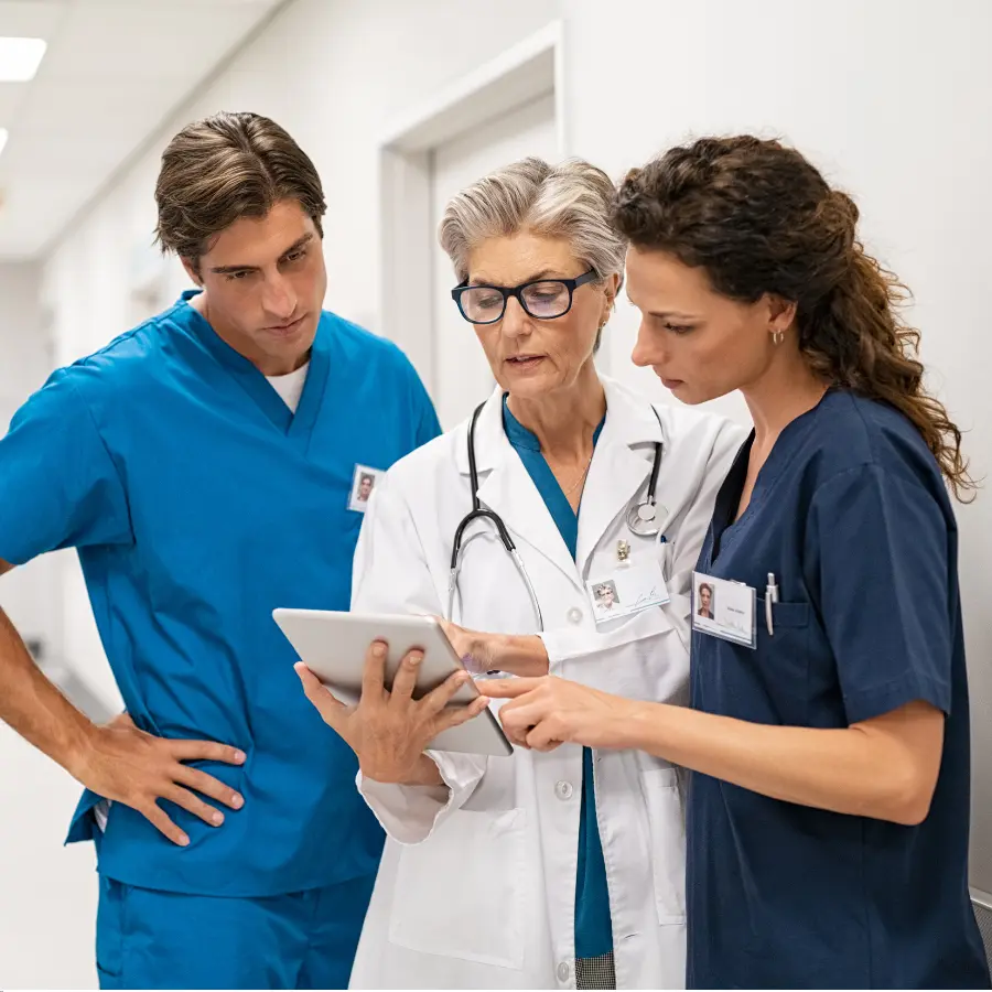 AI scribe solutions assist healthcare professionals as a doctor and two nurses review patient information on a digital tablet