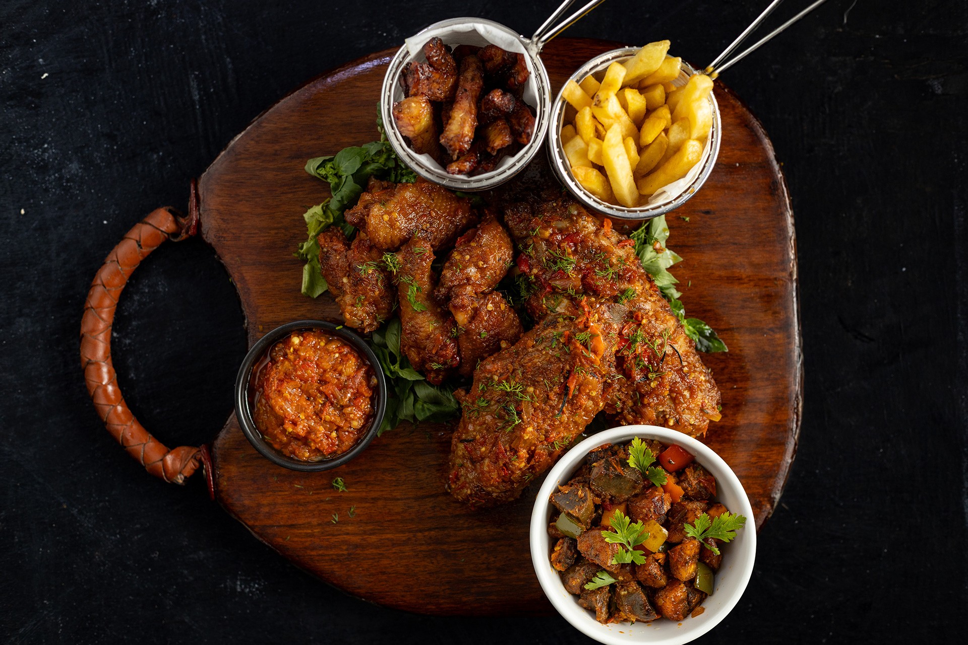 A plate of African food served at Yajee, featuring a colorful and flavorful assortment of traditional dishes, beautifully presented on a restaurant table.