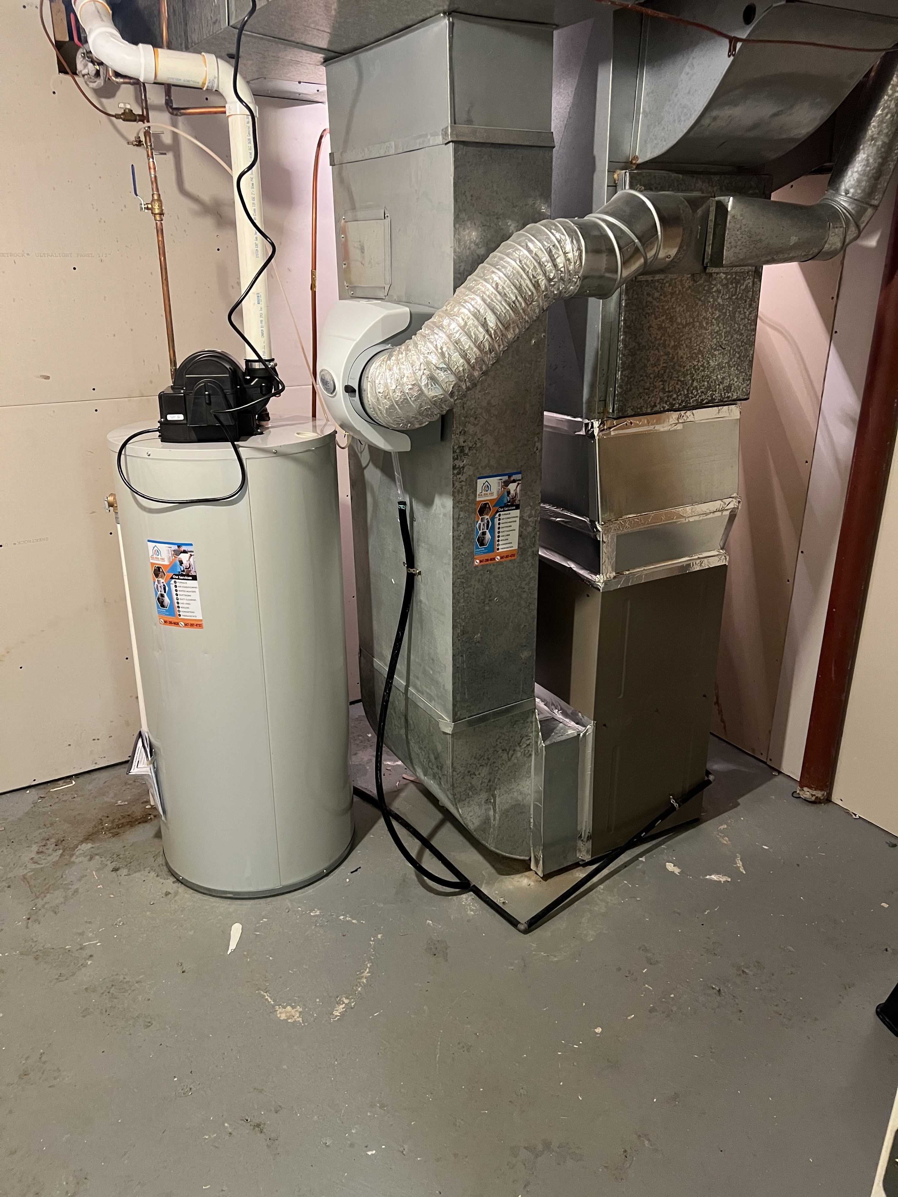 HVAC technician installing a heat pump system on an exterior wall