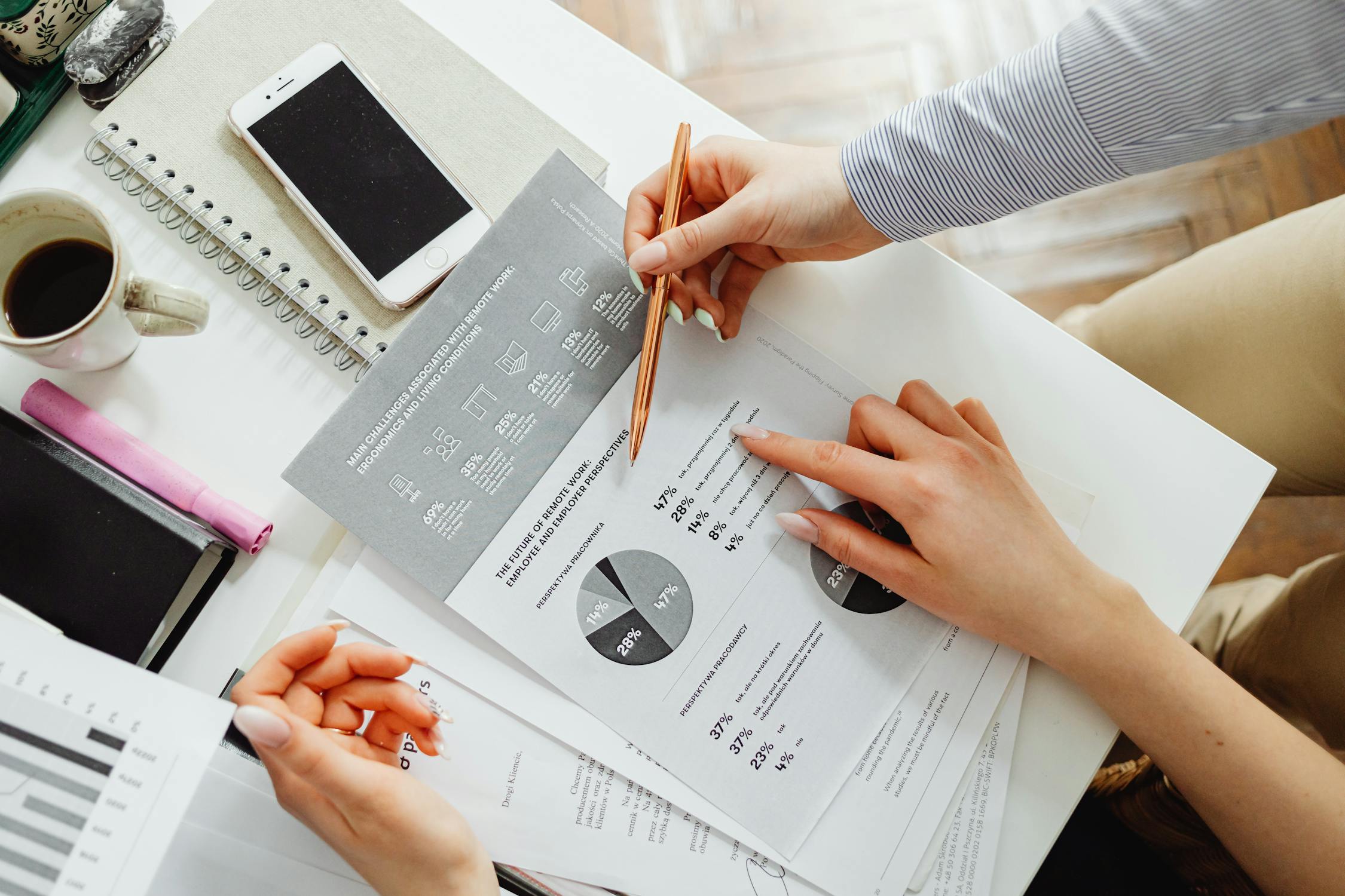 Person reviewing financial documents and charts at a desk