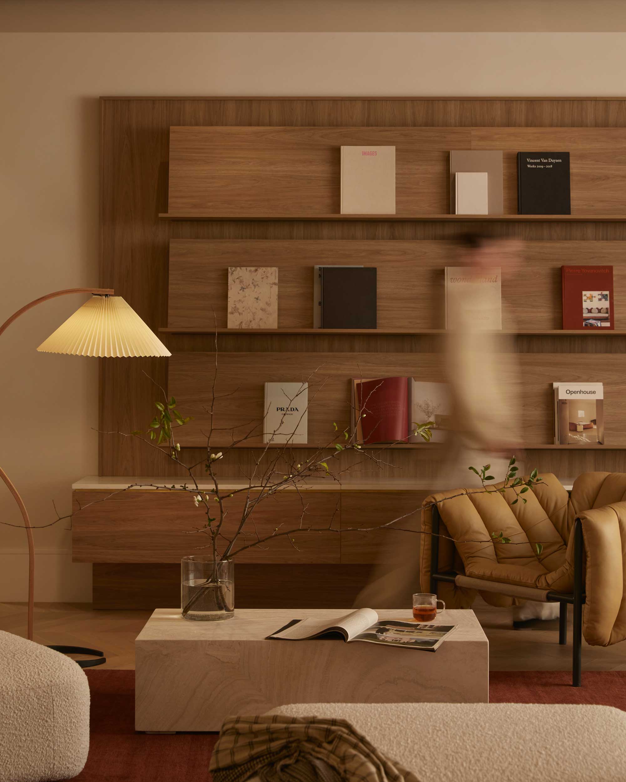 Eclat lounge interior with timber shelving, sculptural furniture and warm natural light.