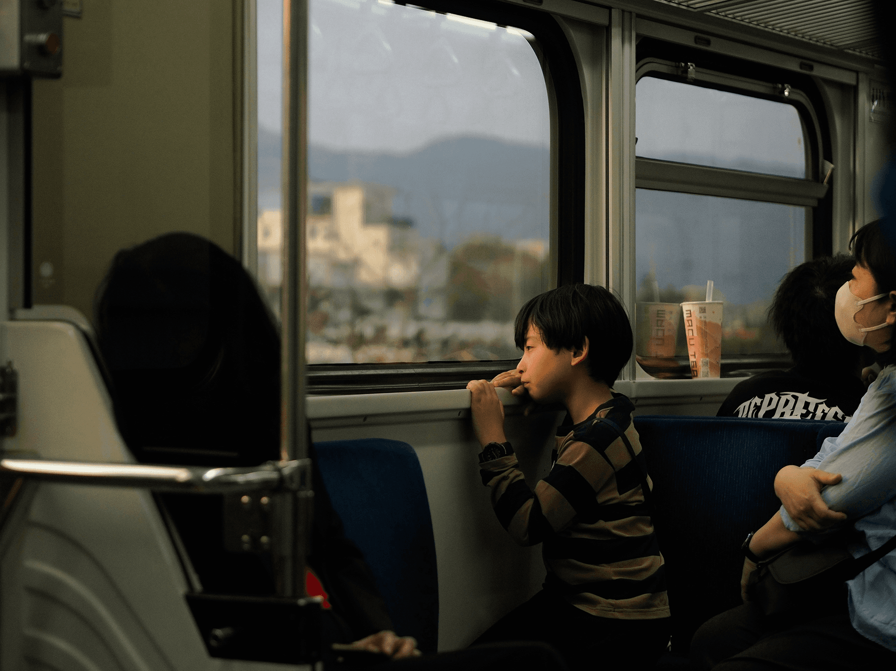Young boy looking out train window.