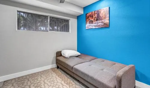 Lounge with a futon and blue accent wall, Family Reunion Home in North Las Vegas