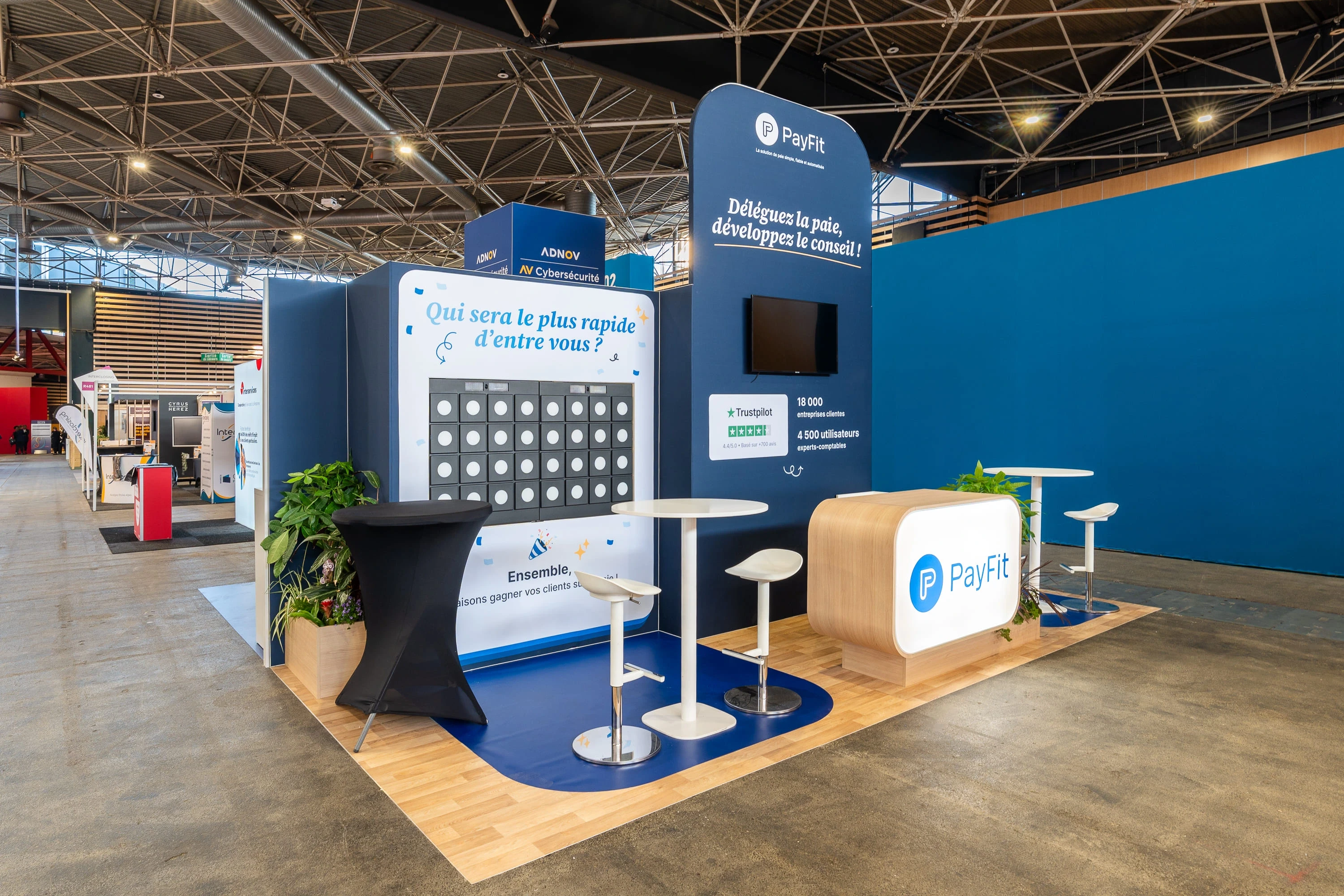 Espace d’échange du stand PayFit signé Expace avec panneaux pédagogiques et zone assise