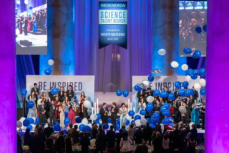 woman in a lab holds up samples. She's doing science research in high school