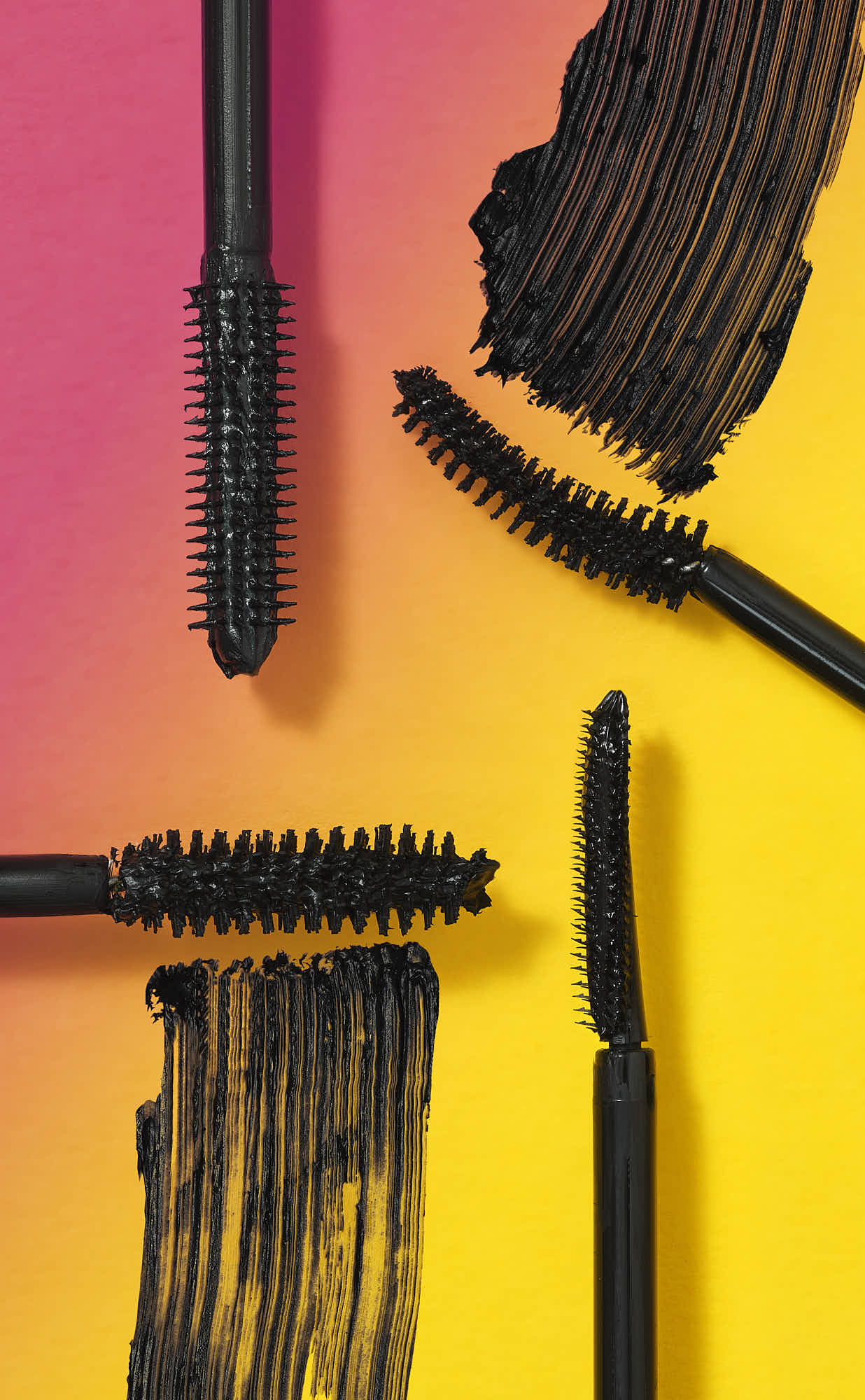 Abstract image featuring dark shapes against a vibrant gradient of pink and yellow. Feels modern and artistic.