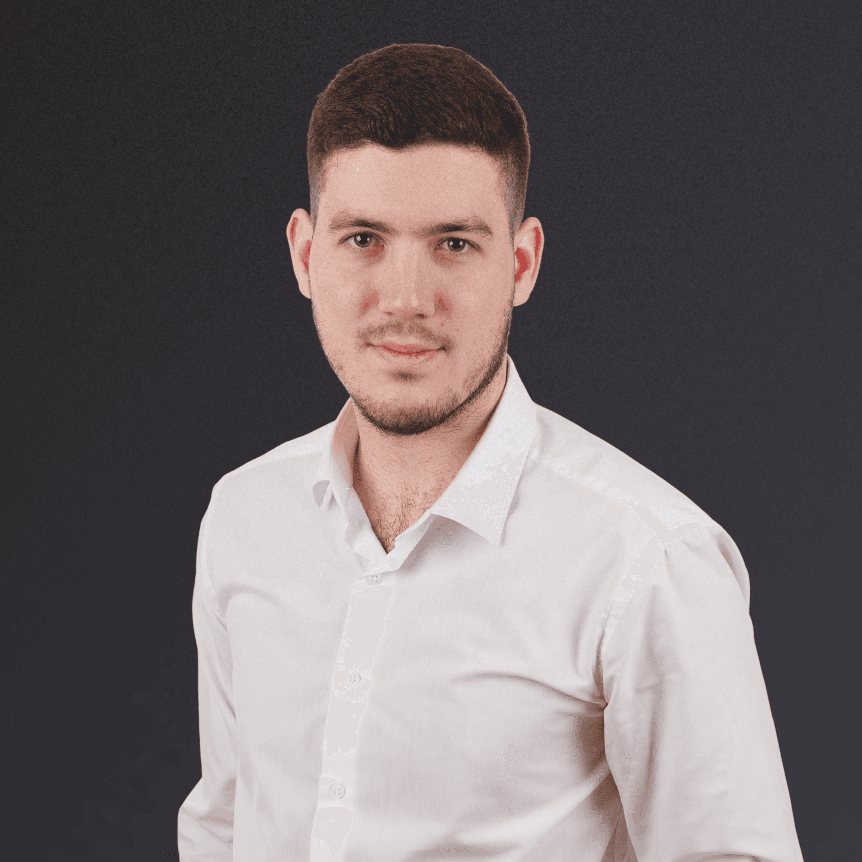 Woman with a short haircut smiling confidently, wearing a blazer and standing in warm natural light with modern architecture behind her.