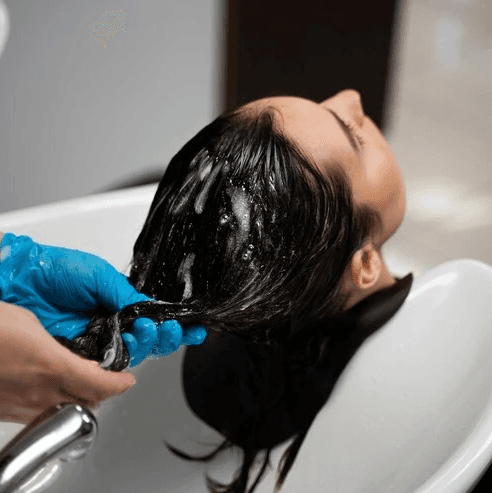 woman in gray sweater holding white clothes hanger
