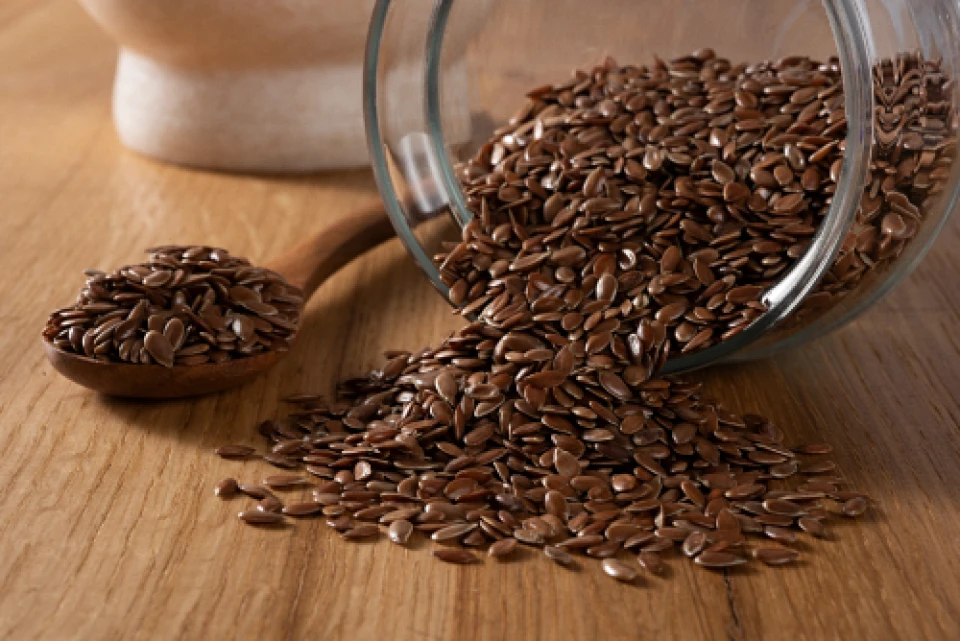 flaxseeds spilling out of a glass bowl
