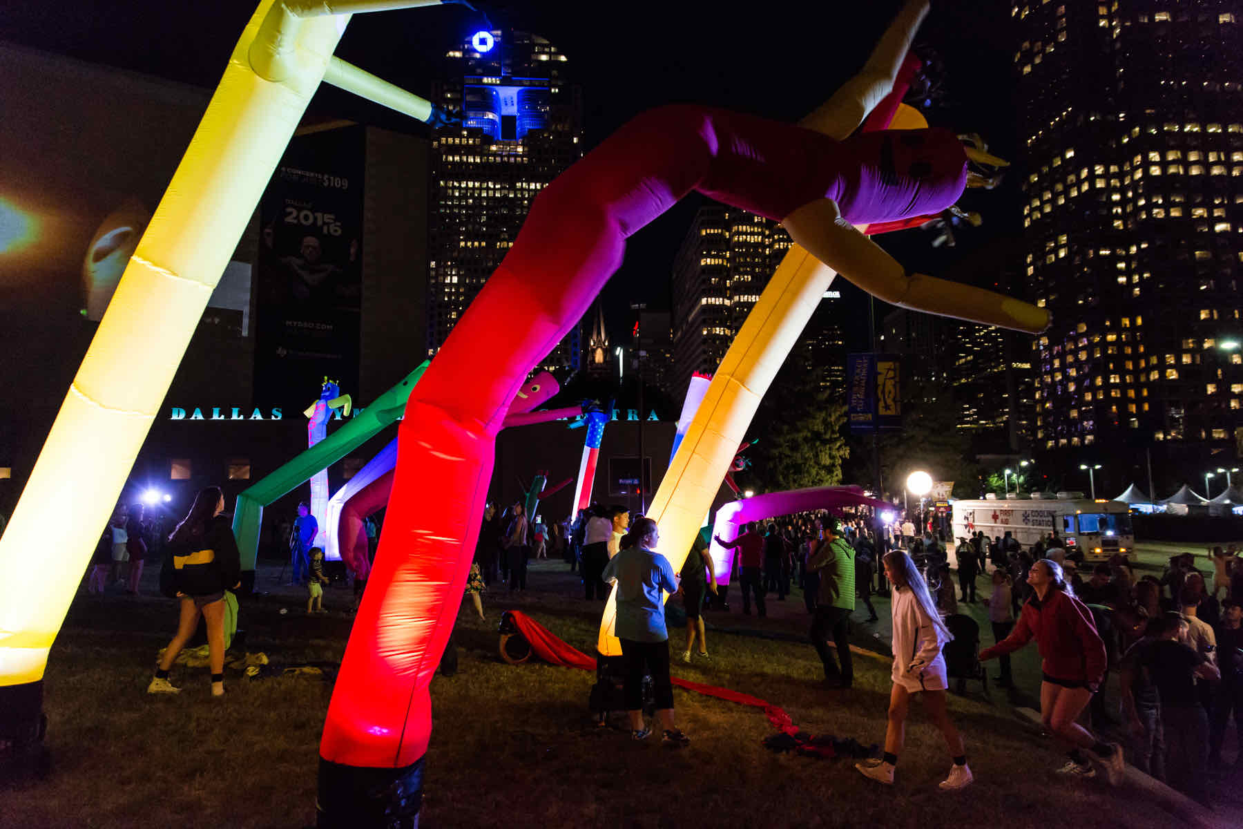 Brightly colored inflatable structures in red and yellow illuminated at night, surrounded by festive lights.