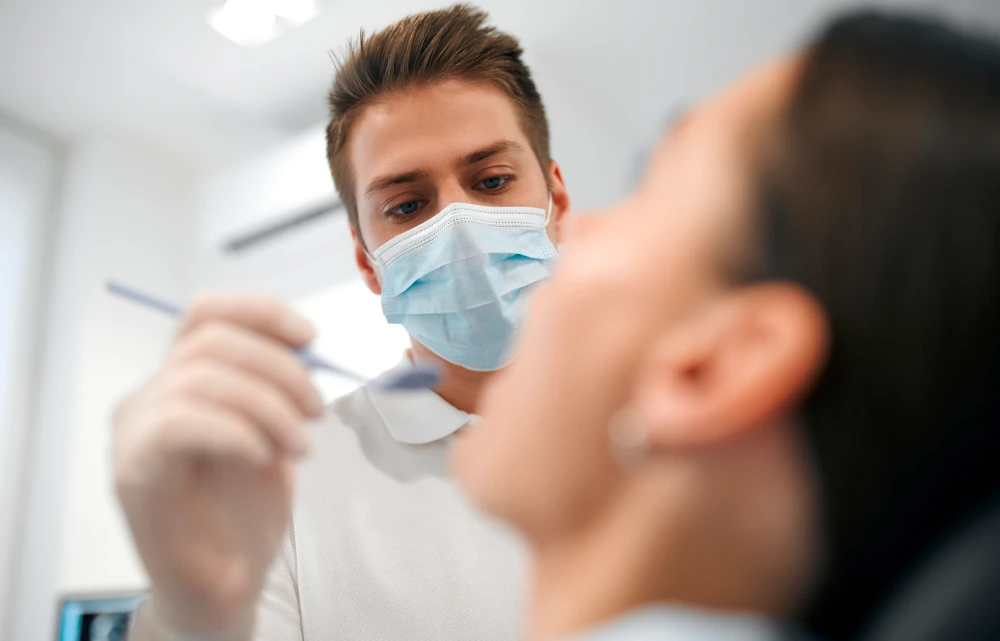 Kobieta z uśmiechem prezentująca efekty bondingu na swoich zębach.