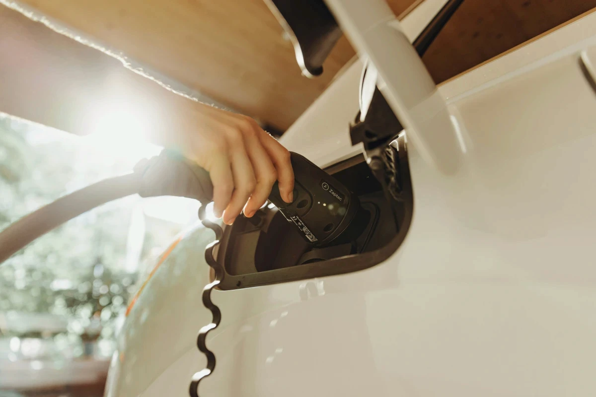 Hand plugging Zaptec charger into electric vehicle.