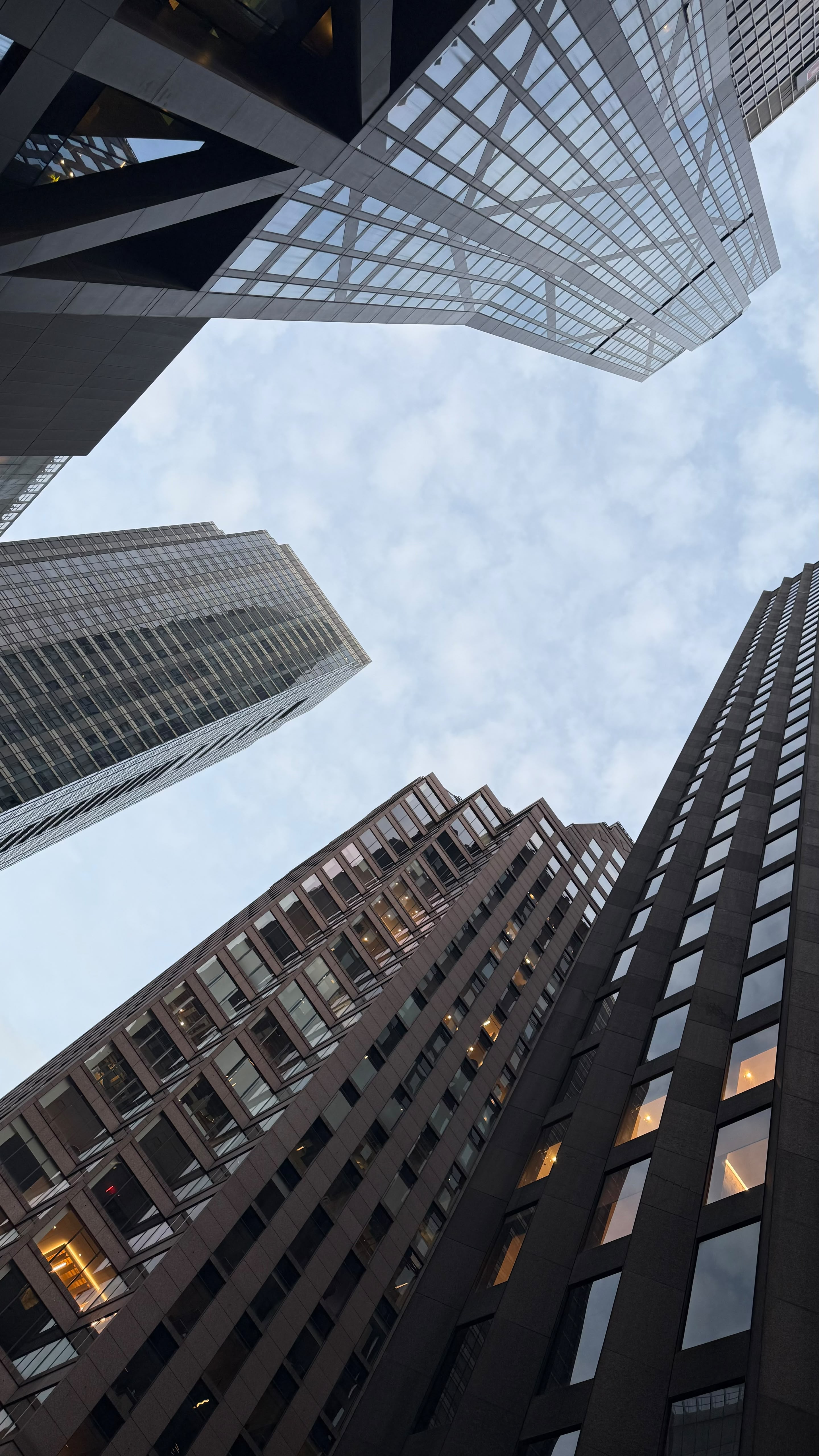 Low-angle view of illuminated skyscrapers at dusk.
