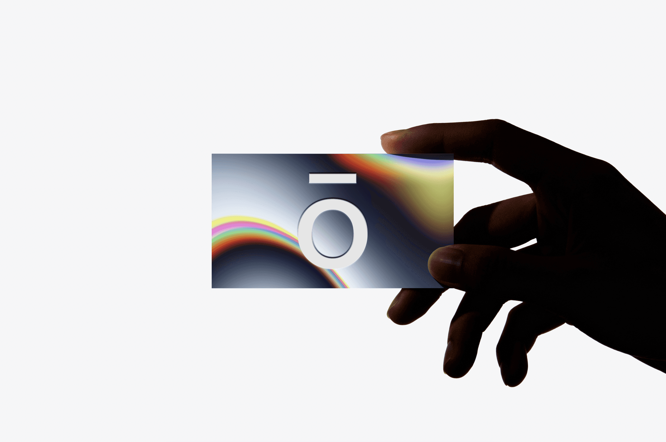 Hand holding a card with a white "O" symbol against a dark background with rainbow light leaks.