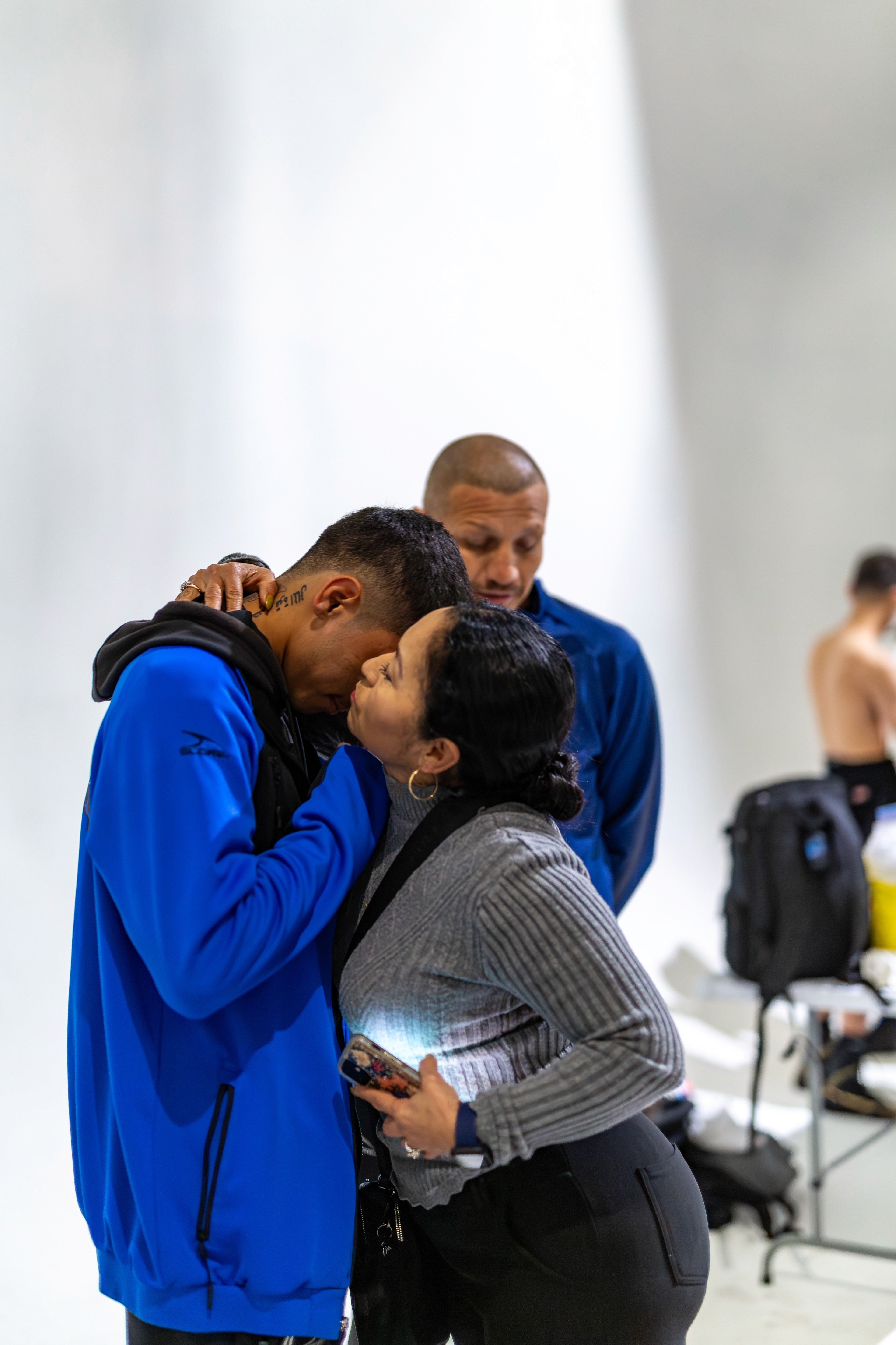 George "El Phantasma" Navarro praying with his tia before the fight while Jesús Soto Karass stands quietly and respectfully nearby.