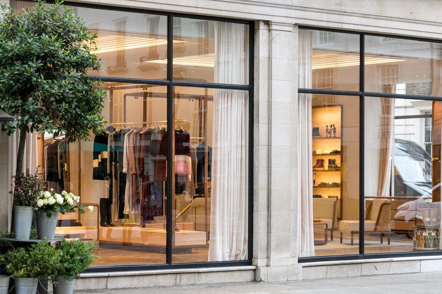 The exterior of a high-end boutique with large glass windows and a display of fashionable clothing and accessories.