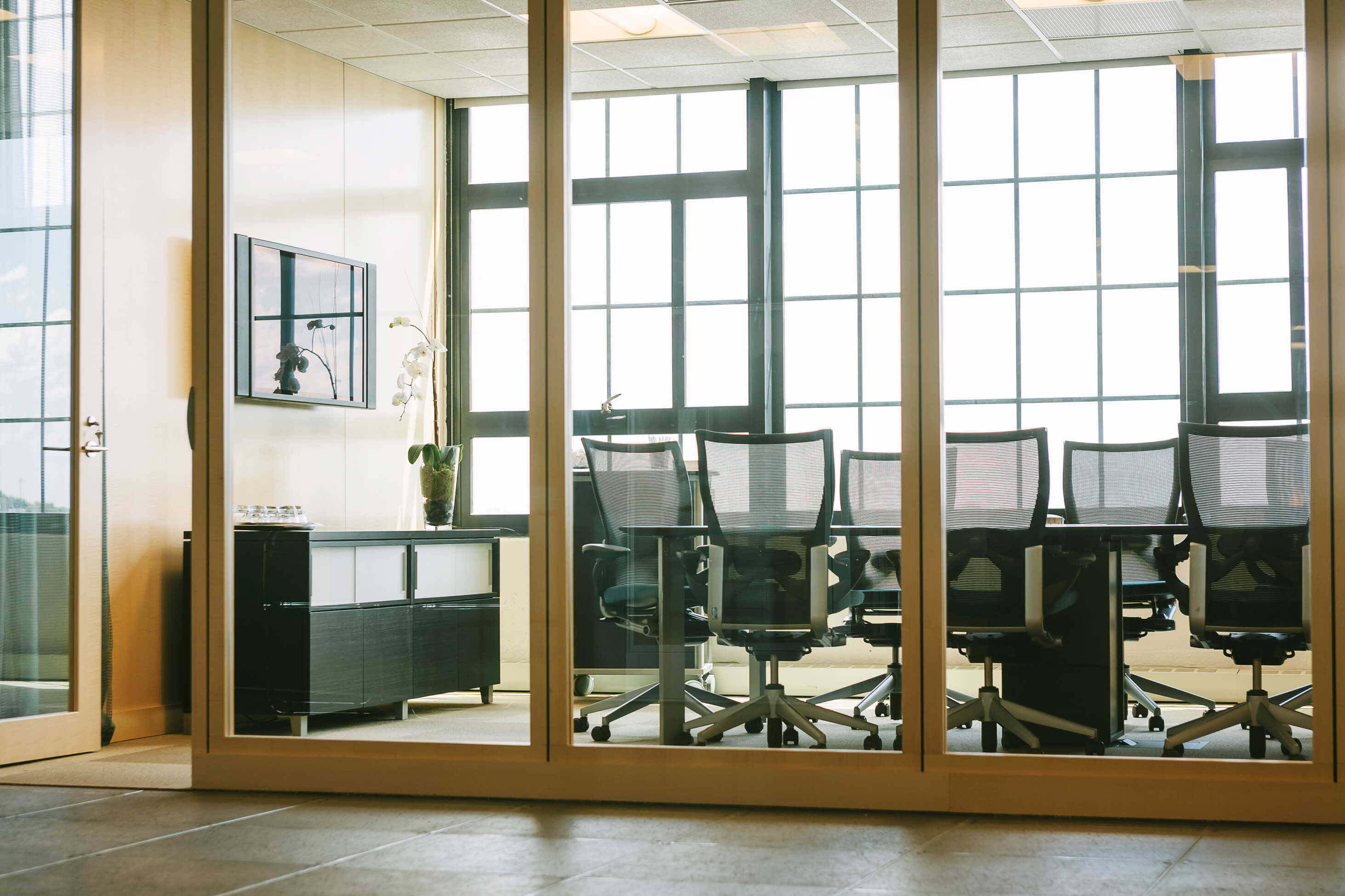 Black and white image of people working at a table with laptops, showing hands gesturing during discussion of digital content displayed on screens, with fabrica® logo in the corner.