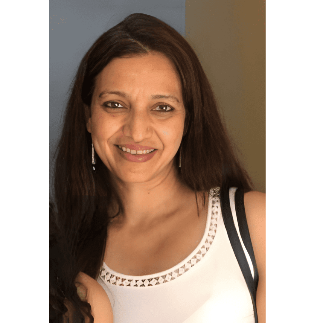 A person with short blonde hair holds a vintage camera.