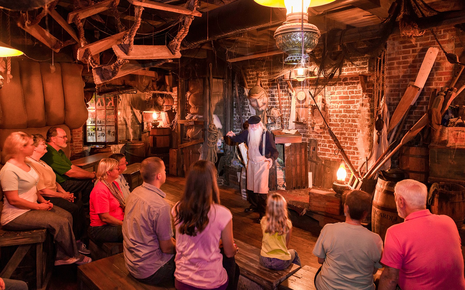 Audience listening to a storyteller in a dimly lit room on the Boston Ghosts & Gravestones tour.