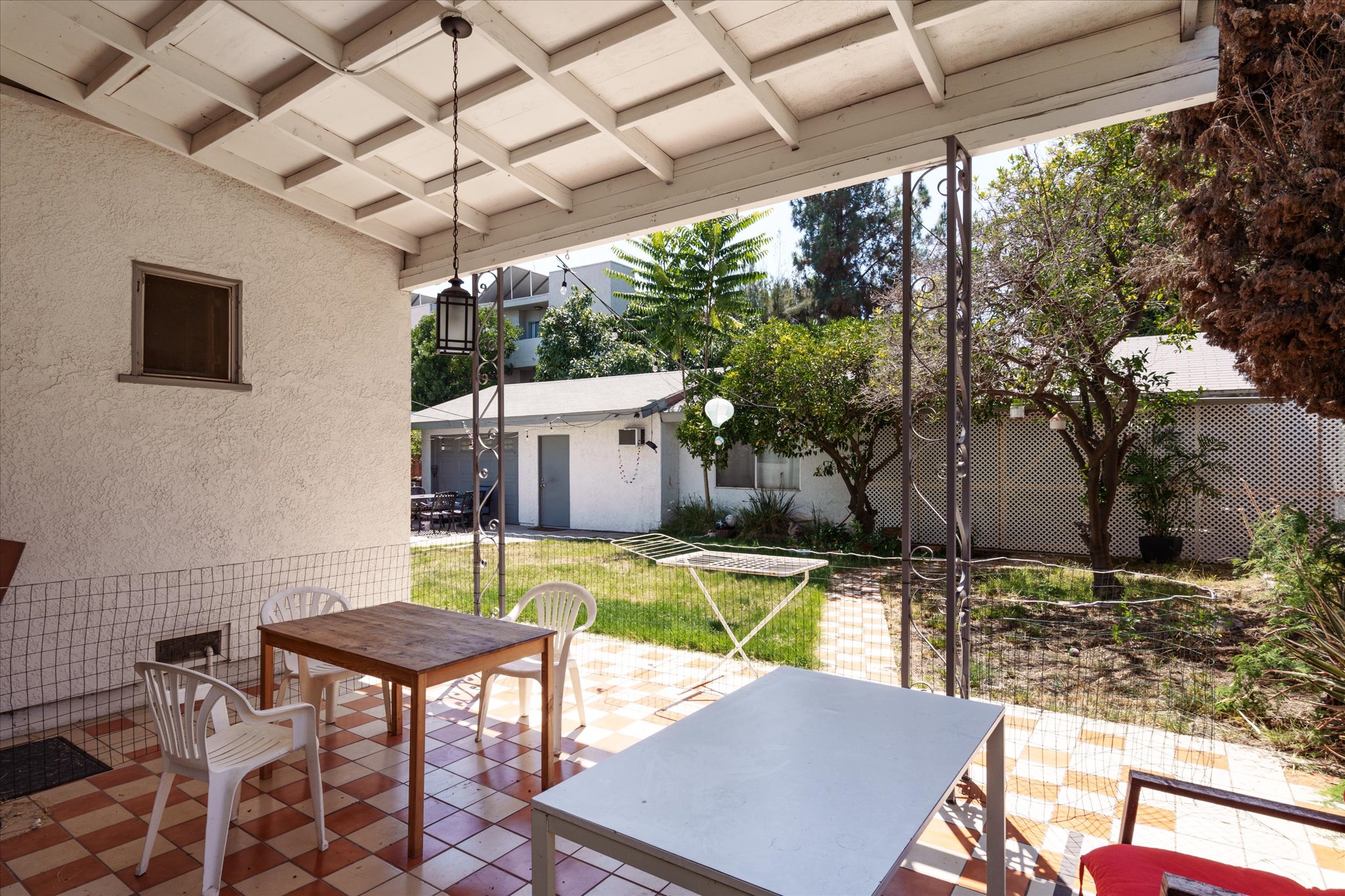 A cozy patio scene at 1807 n van ness, surrounded by greenery and a view of nearby buildings in bright daylight.
