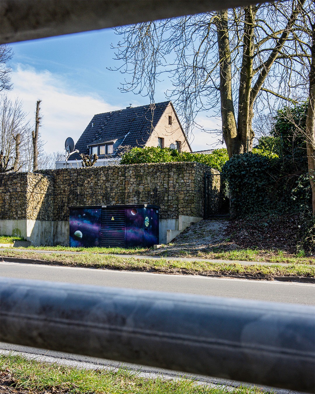 Street with colorful outer space scene on electrical box / Spray urban street art