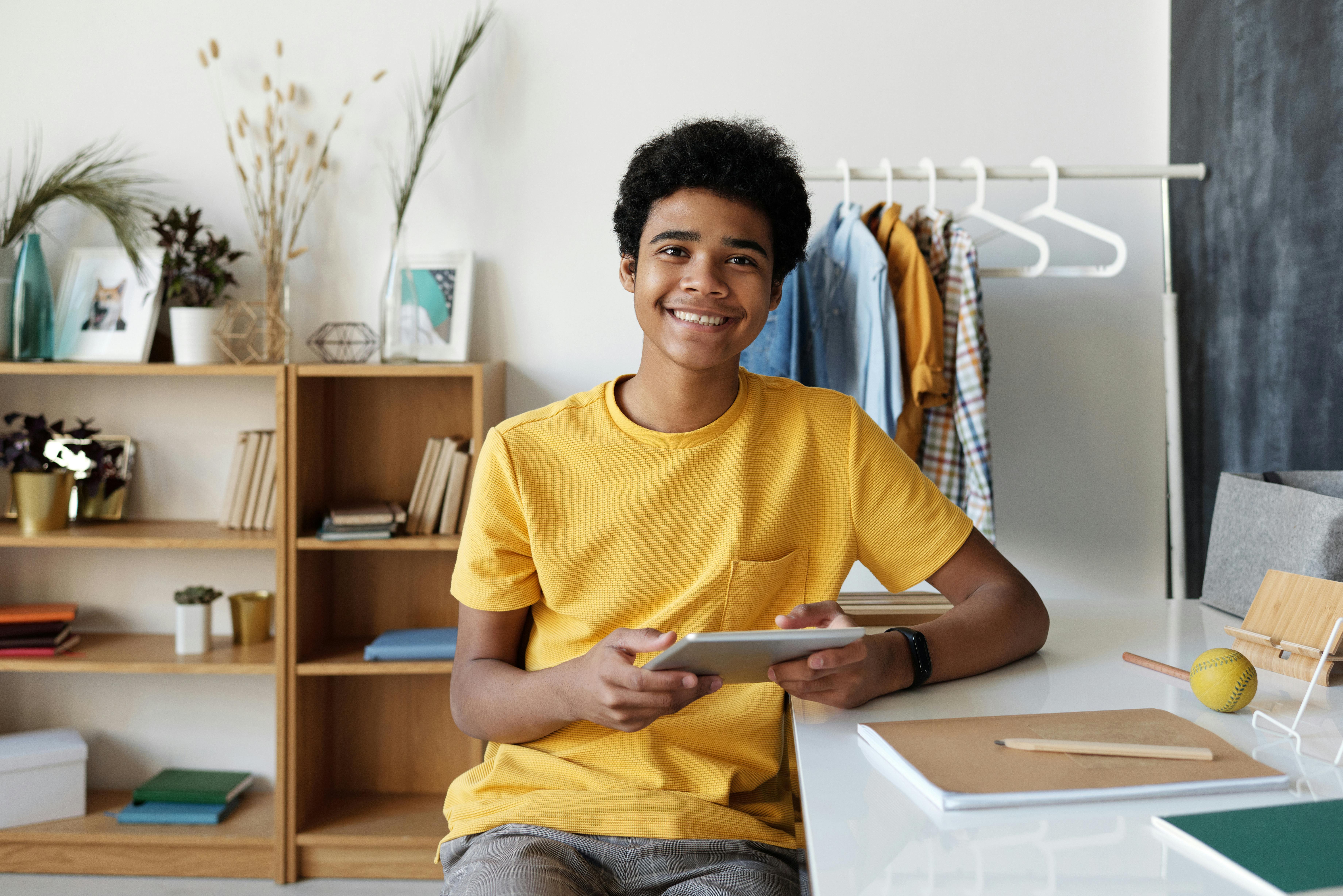 a teenage boy holding a tablet