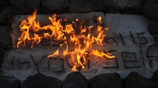 an arrangement surrounded with stones and the words formed with sticks: the best investment is in yourself; the wording is set on fire