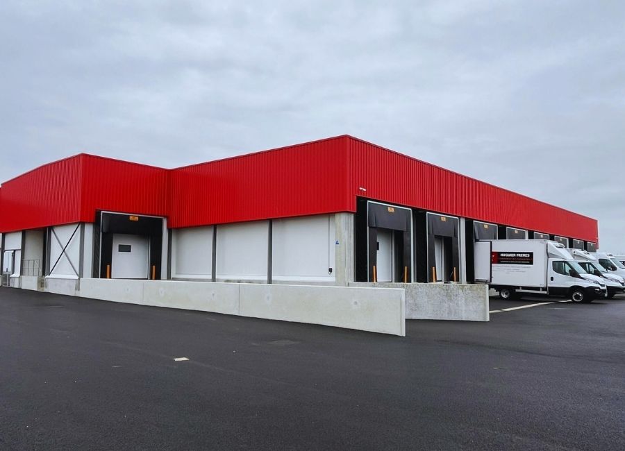 Bâtiment commercial neuf avec toiture rouge et façade blanche et noire, style contemporain.