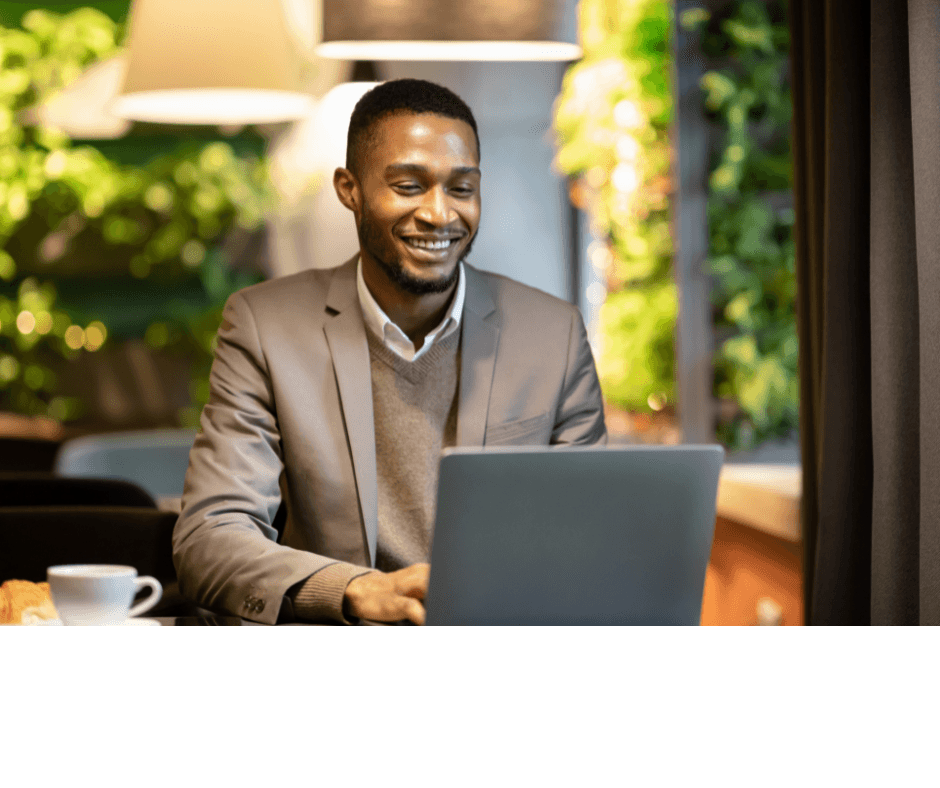 Man in a suit smiling and using his computer.