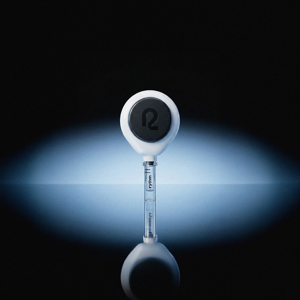 Rythm at-home blood collection device centered against a dark background with soft blue light, highlighting the device used for monthly biomarker testing.