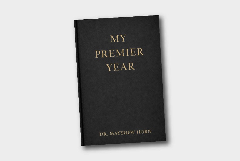 A white ramekin filled with chocolate mousse and topped with strawberries on a table. 