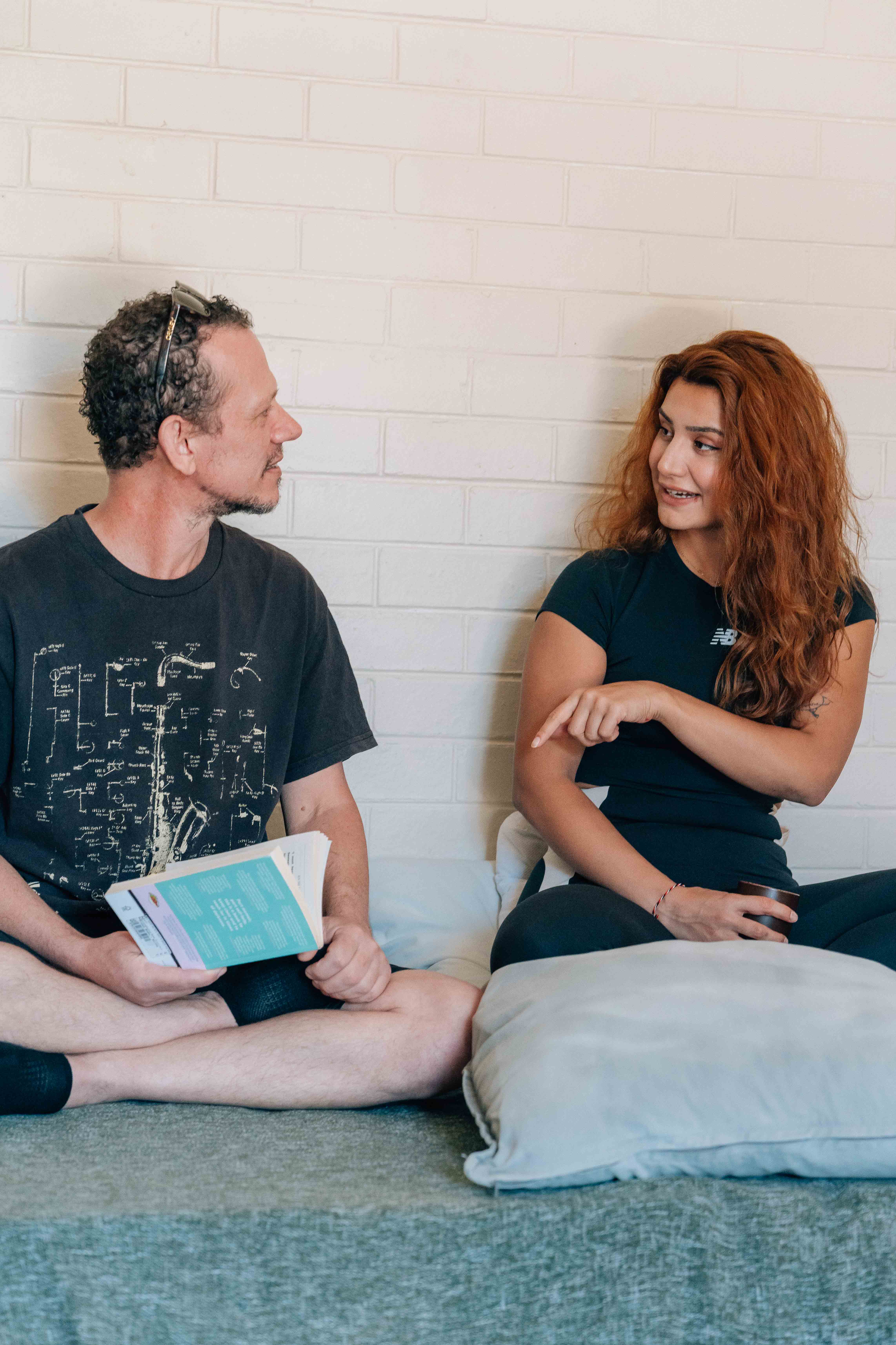 a shirtless man sitting on a rug in a living room