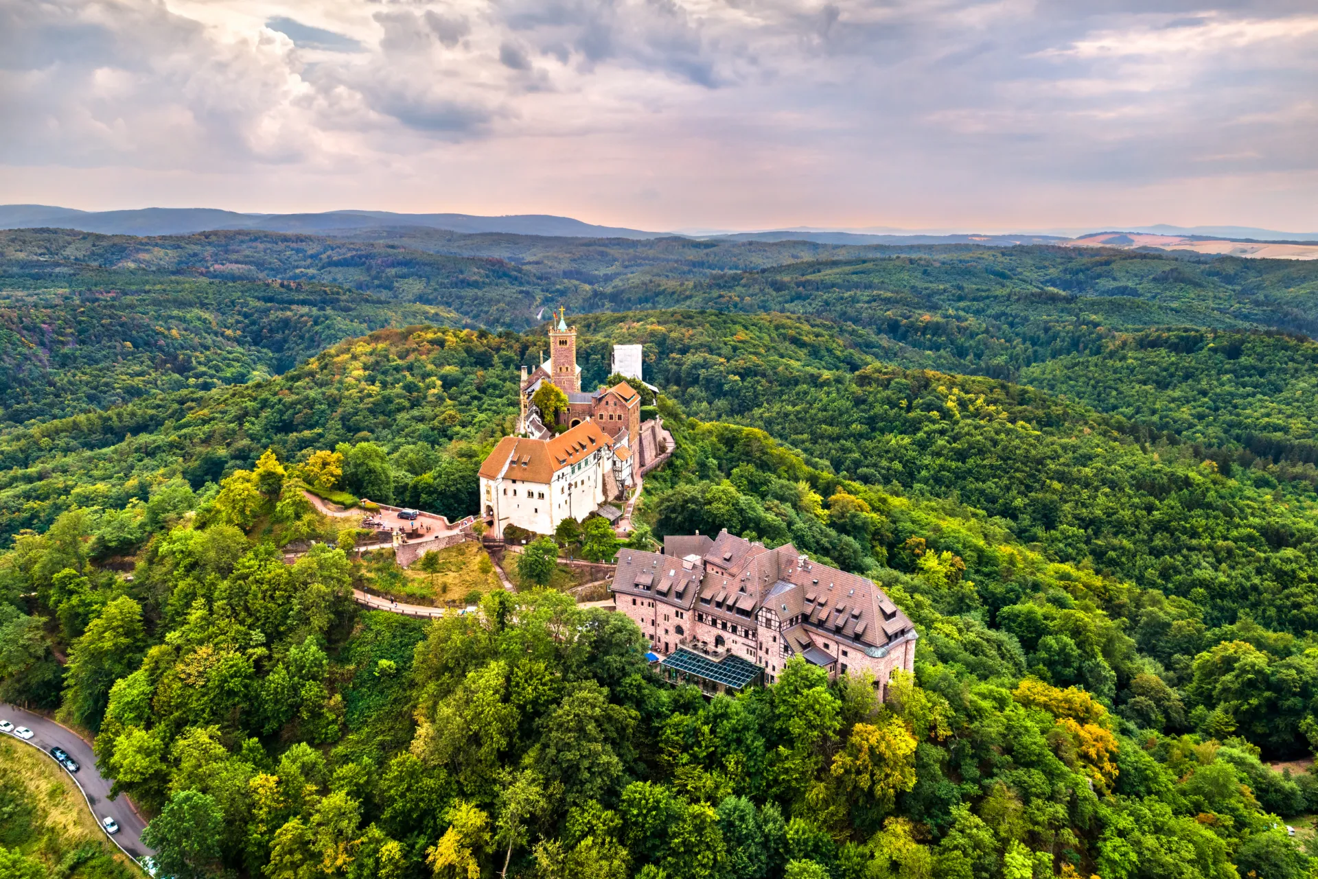 Eine Burg in Tühringen auf einem Berg. Die Burg ist umgeben von einem dichten Wald.