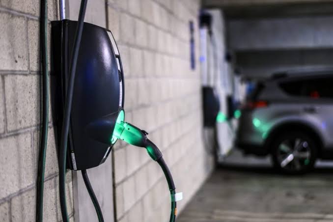 Véhicule électrique devant borne de recharge
