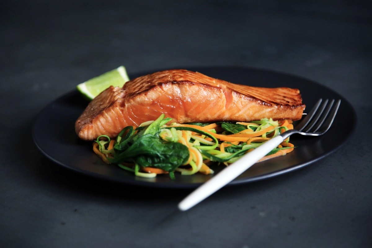 A plate of grilled salmon served with cooked vegetables, a food-first source of anti-inflammatory omega-3 fats