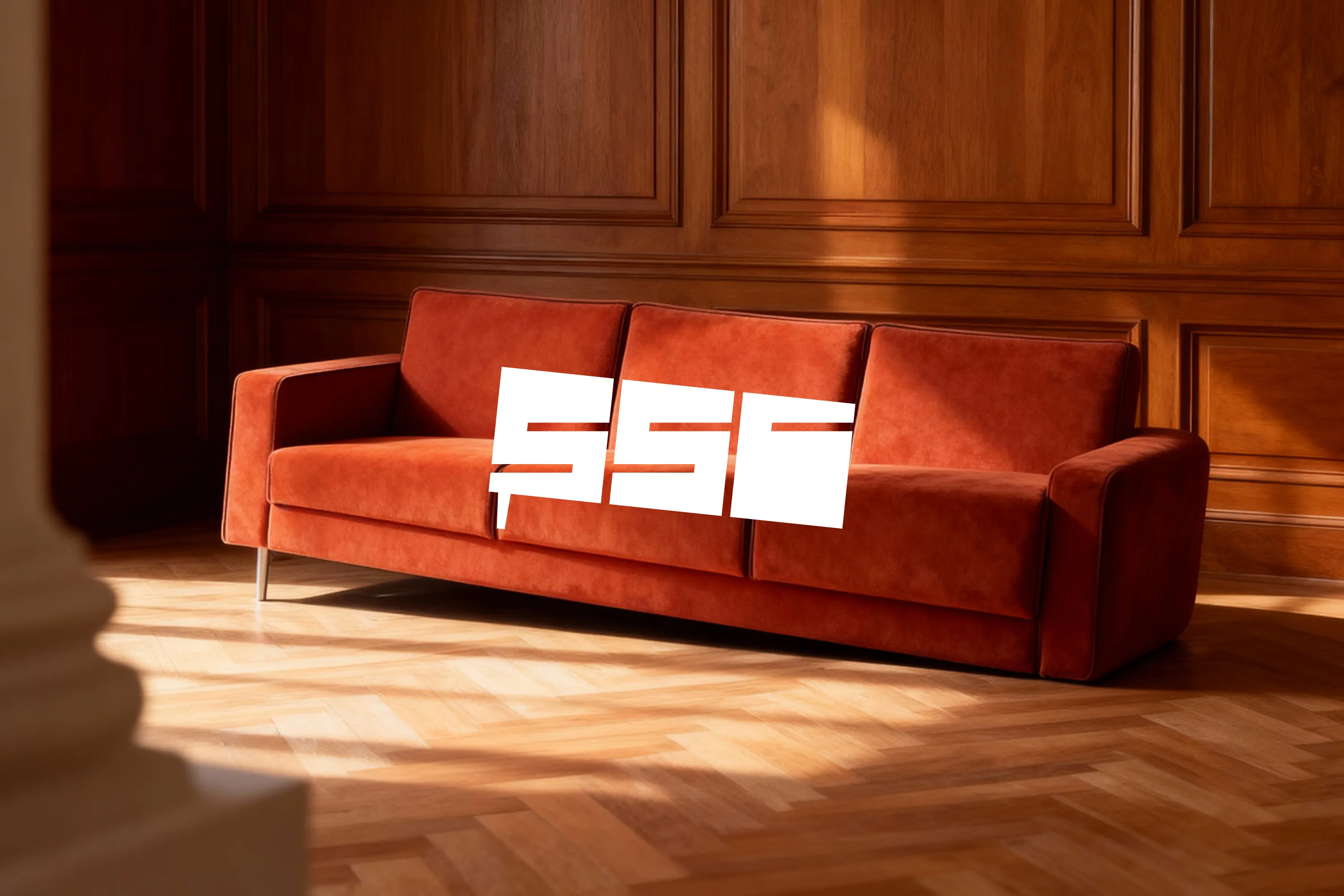 Keyvisual für The Sunken Sofa Company: Modernes, rostrotes Sofa in einem luxuriösen Raum mit Fischgrätparkett und markantem Logo-Overlay.