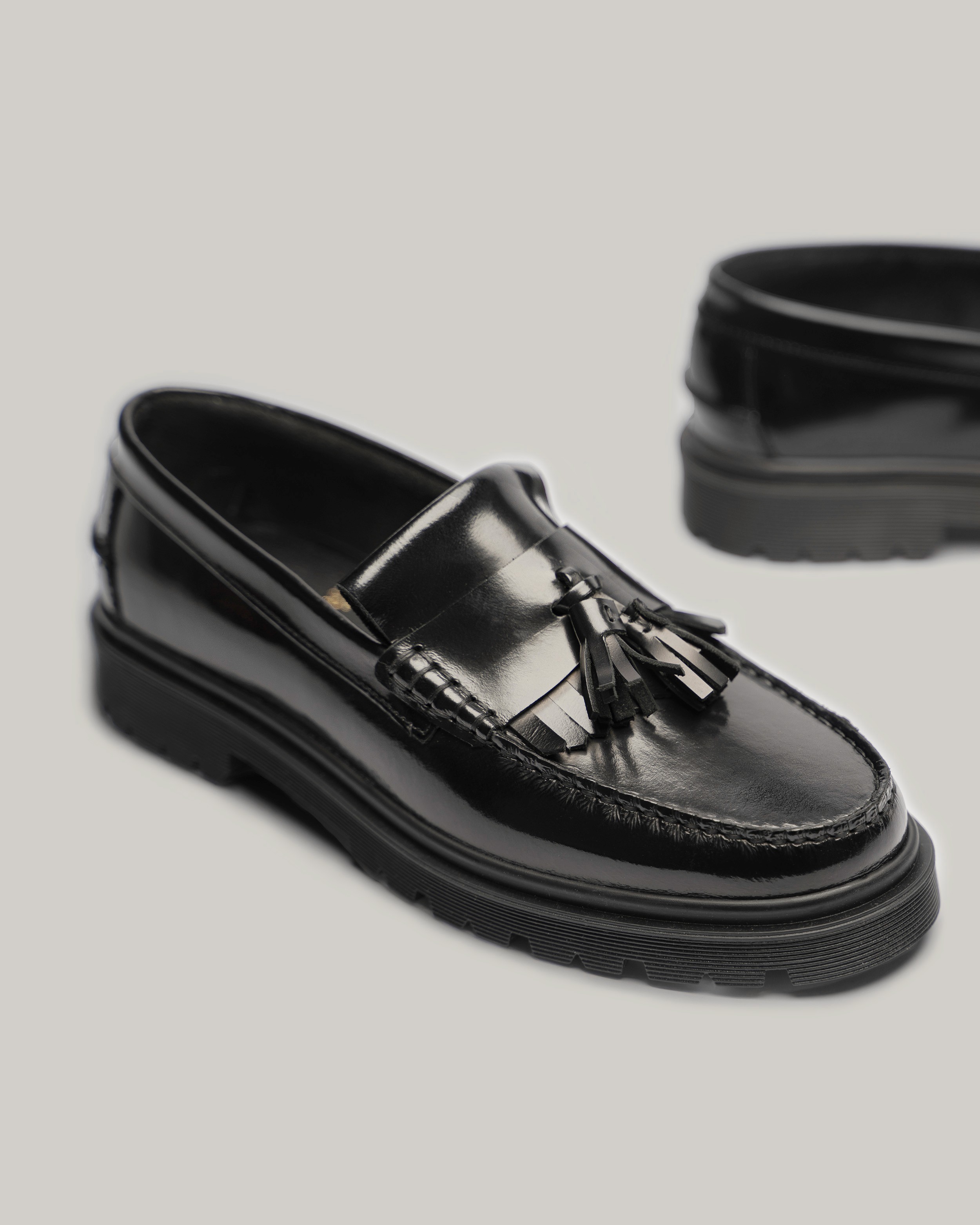Packshot de mocassins noirs vernis à pampilles, pate mexicaine et semelle commando, vue de 3/4