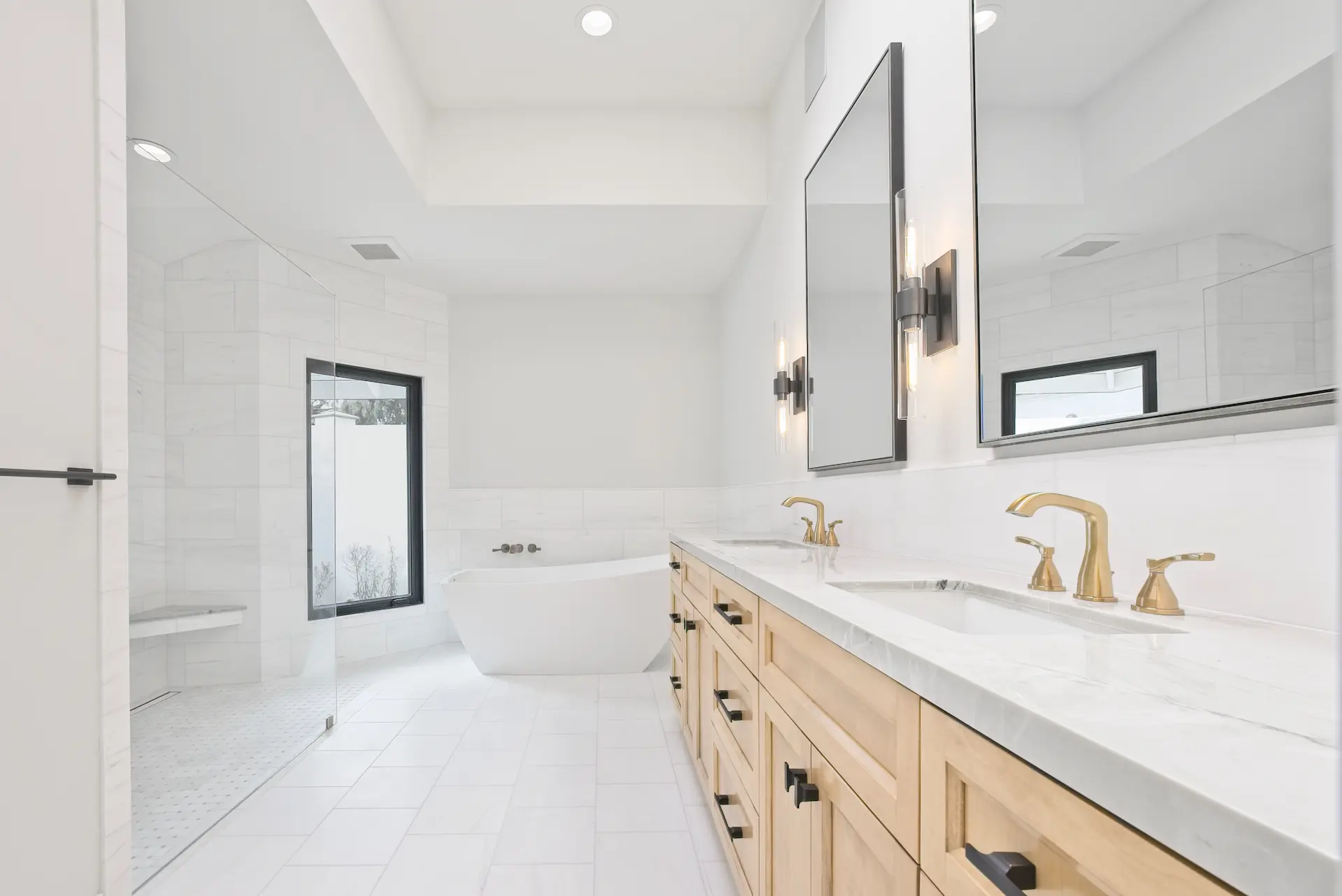 Wide shot in the primary bathroom featuring the double vanity and elegant free-standing tub, creating a sanctuary of relaxation in the Dana Point Full Remodel. Photo by Todd Huge.