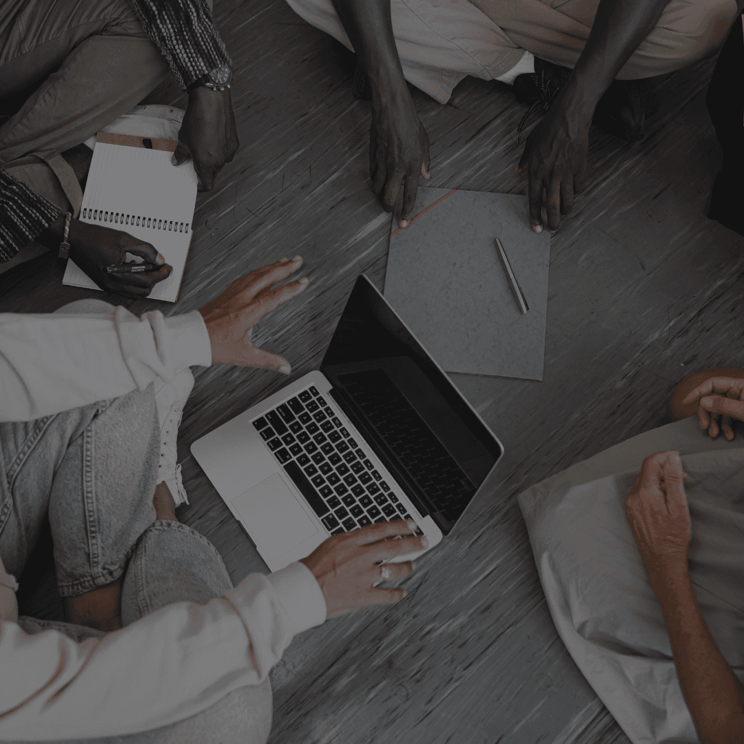 Aerial view of hands near a laptop, surrounded by papers and a cozy setting.